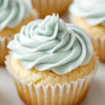 Gluten-free vanilla cupcake with light blue frosting in a white paper liner